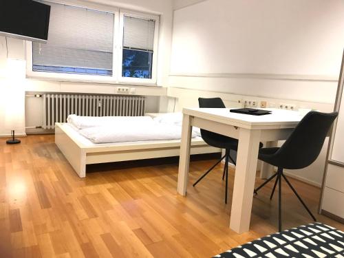 sypialnia z łóżkiem, biurkiem i stołem w obiekcie Relax Aachener Boardinghouse Budget w Akwizgranie