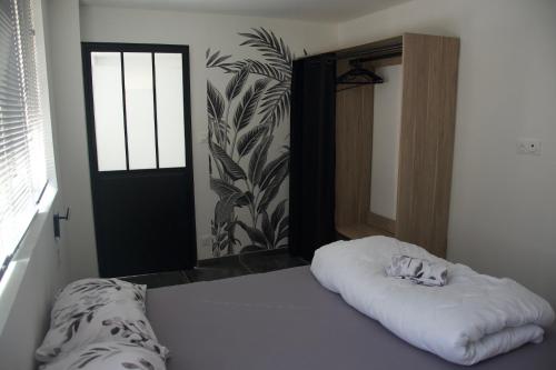une chambre avec un lit avec une couverture blanche et une porte dans l'établissement Appt 4/6 pers à 400 mètres de la plage, à Dunkerque