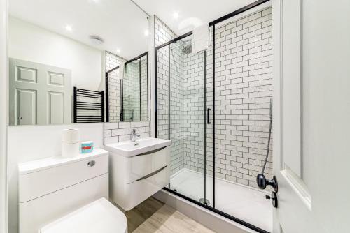a bathroom with a toilet and a sink and a shower at Pass the Keys Luxury Converted Victorian Flat in Leafy Highbury in London