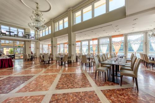 a dining room with tables and chairs and windows at Hotel Bazzoni in Tremezzo