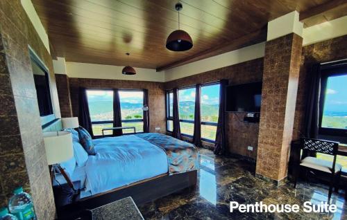 Schlafzimmer mit einem Bett, einem TV und Fenstern in der Unterkunft Hotel Poles Apart in Shillong