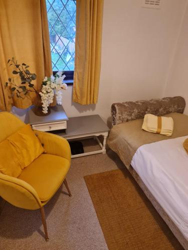 a bedroom with a bed and a chair and a window at The Cozy Shelter 