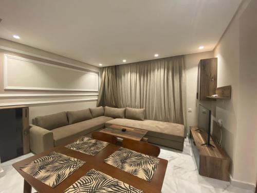 Hilbert Princesses - Brand new furnished apartments في الدار البيضاء: غرفة معيشة مع أريكة وطاولة