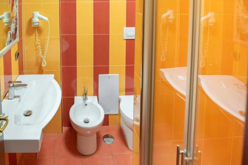 a bathroom with a toilet and a sink and a shower at Hotel Bellavista in Marina di Varcaturo