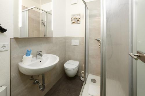 een badkamer met een wastafel, een toilet en een douche bij BRN Ankerplatz in Laboe