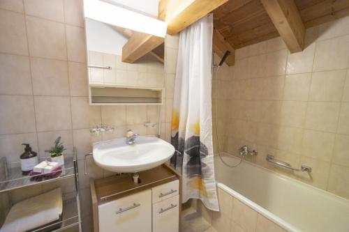 a bathroom with a sink and a bath tub at Chasa Sur Chafarrer in Scuol