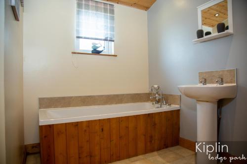 ein Badezimmer mit einer Badewanne und einem Waschbecken in der Unterkunft Essex Lodge in Richmond