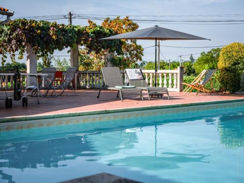 une piscine avec des chaises et un parasol dans l'établissement Tonnelle Gaillacoise - Piscine - Climatisation, à Gaillac