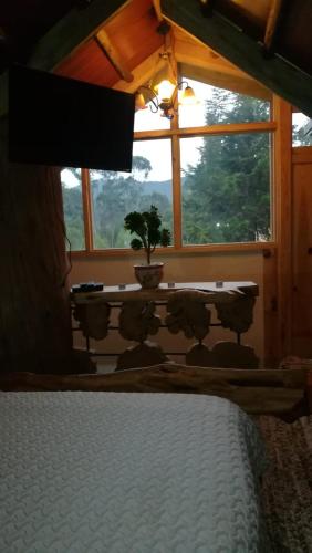 a bedroom with a bed in front of a window at Cabaña en la Calera Cerezos in La Calera