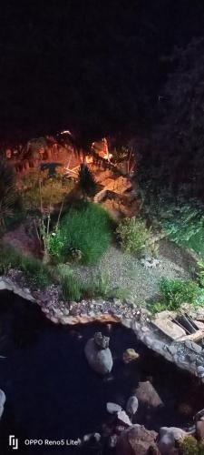 a model of a garden with a pond at night at Cabaña en la Calera Cerezos in La Calera