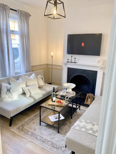 a living room with a couch and a fireplace at Carlton House in Northampton
