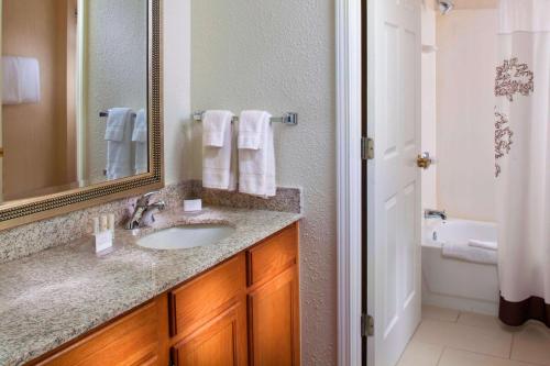 a bathroom with a sink and a mirror and a tub at Sonesta ES Suites Birmingham Homewood in Birmingham