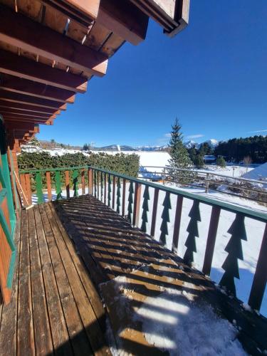 a wooden deck with a view of the snow at Maison de bois finlandaise au pied des pistes in Bolquere Pyrenees 2000