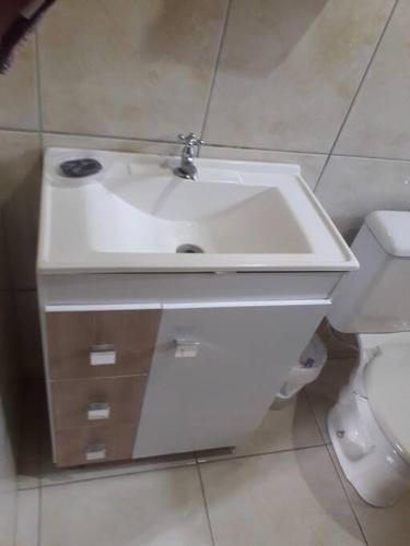 a bathroom with a white sink and a toilet at Casa próximo a praias, trilhas e cachoeiras. in Garopaba