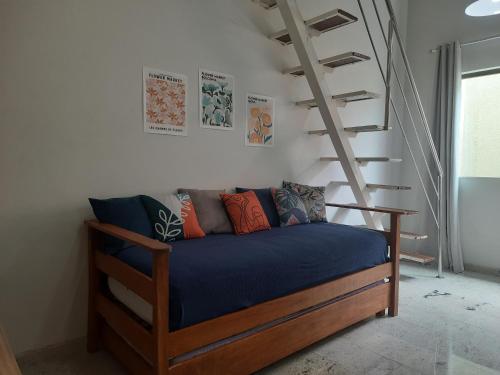 um sofá num quarto com uma escada em Loft tropical na praia de Vilas do Atlântico em Lauro de Freitas