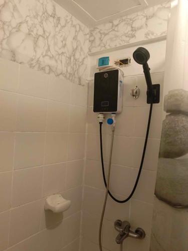 uma casa de banho com um chuveiro e um secador de cabelo na parede em Camella north point 2 bedroom em Dávao