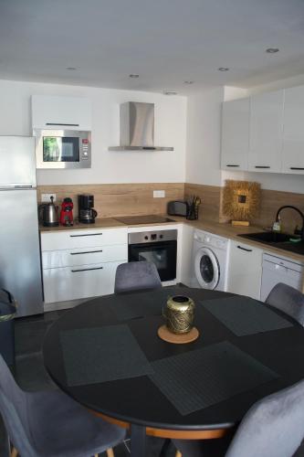 une cuisine avec une table et des chaises et un micro-ondes dans l'établissement Appt 4/6 pers à 400 mètres de la plage, à Dunkerque