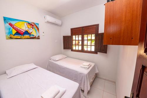 um pequeno quarto com 2 camas e uma janela em Residencial Maragogi em Maragogi