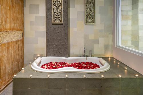 a bath tub filled with lots of red roses at Villa Nora, by Five Elements in Canggu