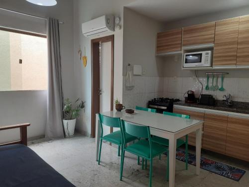 cocina con mesa y sillas en una habitación en Loft tropical na praia de Vilas do Atlântico, en Lauro de Freitas