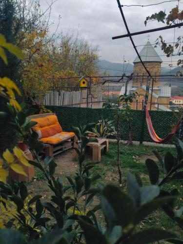 an orange couch and a hammock in a garden at garden and panorama in Mtskheta