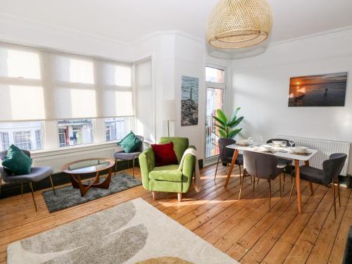 a living room with a green chair and a table at 36A Mary Street in Porthcawl