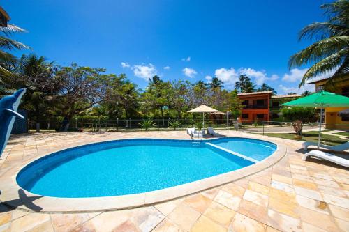 uma piscina com cadeiras e um guarda-sol em Residencial Maragogi em Maragogi