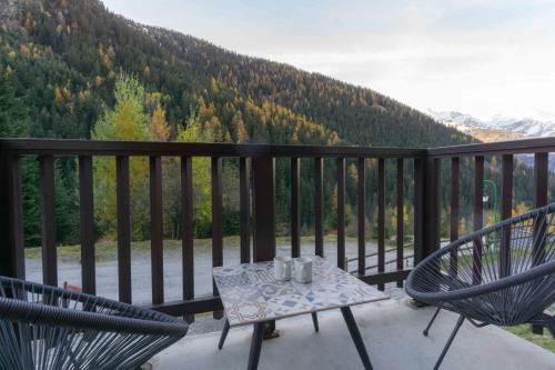 a table and chairs on a balcony with a view at Appart valfrejus in Modane