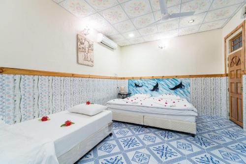 Summer Vibes Beach Front في جزيرة راسدو: سريرين في غرفة ذات بلاط ازرق وابيض