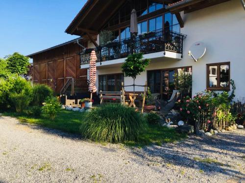 een groot huis met een veranda en een balkon bij Bauniglerhof in Riedering