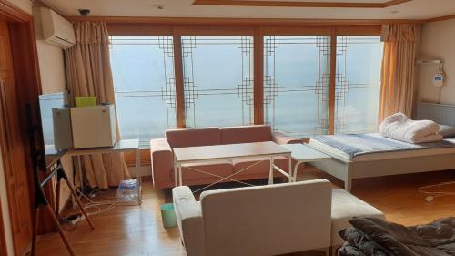 - un salon avec une grande fenêtre et un canapé dans l'établissement dakwan stay, à Séoul