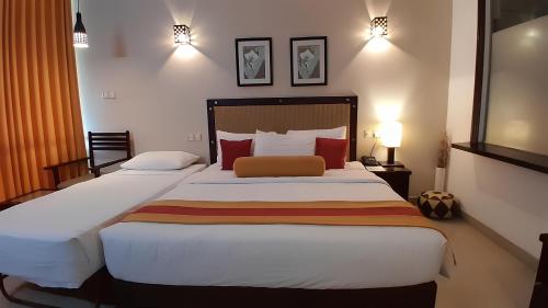a bedroom with a large bed with red pillows at Laya Beach in Wadduwa