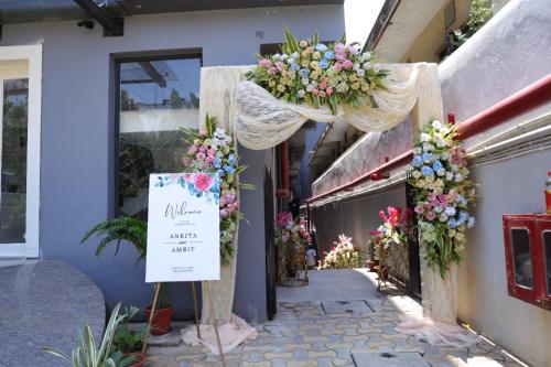 a sign in front of a building with flowers at SM Hives Business Hotel in Bhubaneshwar