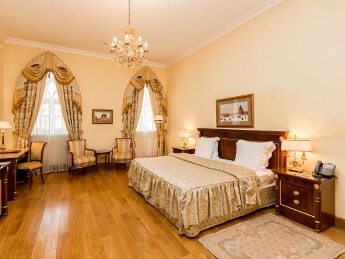 1 dormitorio con 1 cama, escritorio y sillas en Petroff Palace Boutique Hotel, en Moscú
