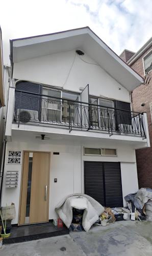 a white house with a balcony and a balcony at Meguro Apartment in Tokyo