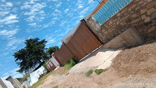 een hek aan de zijkant van een gebouw op een heuvel bij Cabañas El Pirata in Quintero