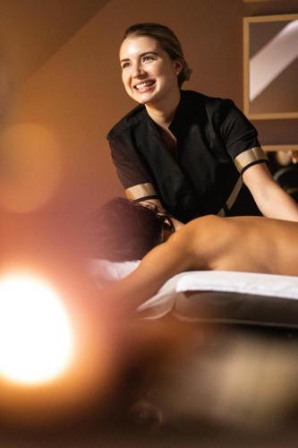 a woman sitting on top of a bed with her legs at Domaine De La Corniche in Rolleboise
