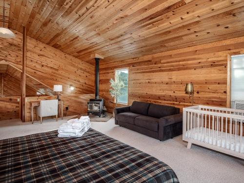 a bedroom with a wooden ceiling with a bed and a couch at Enchanted Oak Cabin in Ruidoso