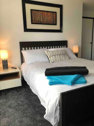 a bed with two towels on top of it at Entire 2 bed modern apartment in Nantwich