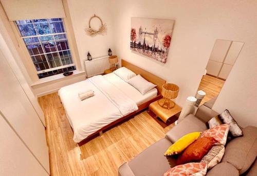 a small room with a bed and a couch at H1: Stunning Large Apt - Under 100m to Piccadilly Circus! in London