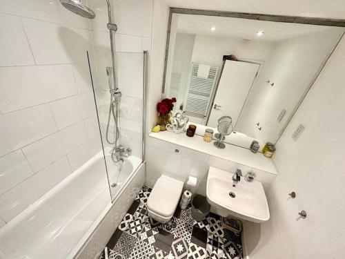 a bathroom with a sink and a shower and a toilet at H1: Stunning Large Apt - Under 100m to Piccadilly Circus! in London