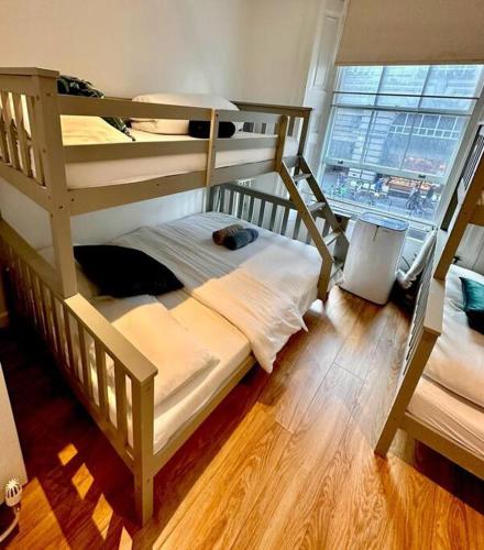 a bedroom with two bunk beds and a window at H1: Stunning Large Apt - Under 100m to Piccadilly Circus! in London