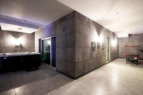 un baño grande con una gran pared de piedra. en Ulsan Samsan Pandora Hotel en Ulsan
