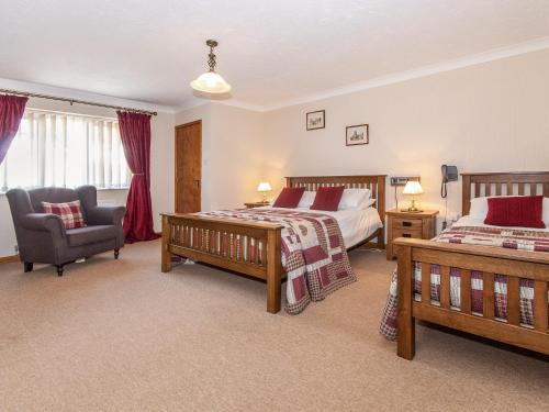 a hotel room with two beds and a chair at Cwtch Lloi - Qc1665 in Llandeloy