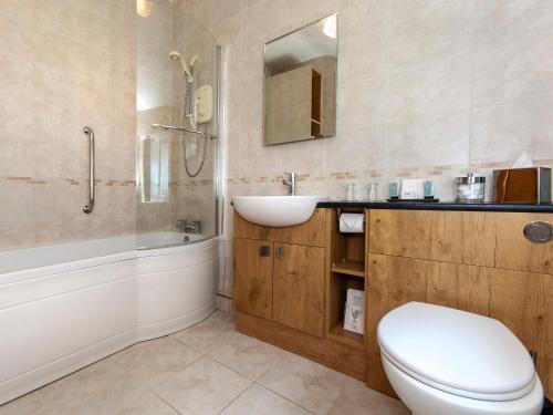 a bathroom with a toilet and a sink and a tub at Cwtch Lloi - Qc1665 in Llandeloy
