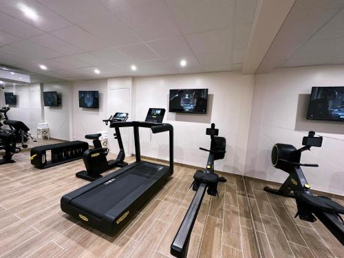 a gym with several treadmills and exercise bikes at Domaine De La Corniche in Rolleboise