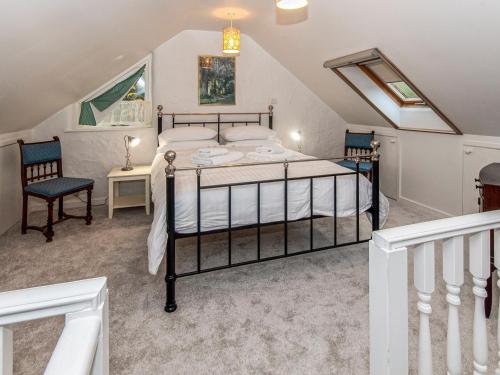 a bedroom with a bed and two chairs at Wisteria Lodge - Qc1677 in Cilgwm