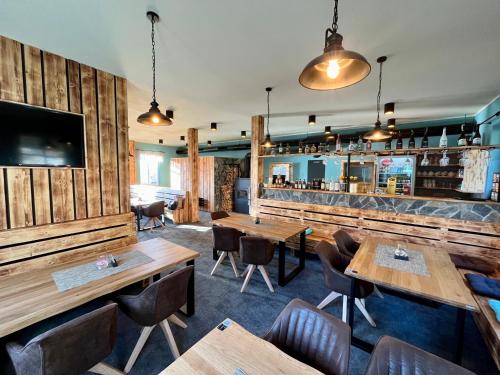 un restaurante con paredes de madera, mesas y sillas en Ludvíkova bouda, en Janske Lazne