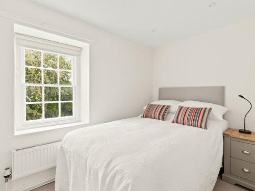 a white bedroom with a bed and a window at Croft Y Beudy in Henfynyw Upper