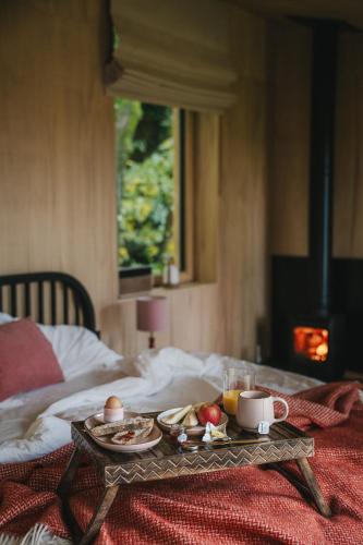 a tray of food on top of a bed at RewildThings Treehouses in Gloucester